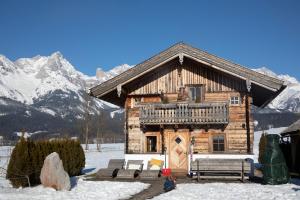 萨菲登安斯泰内嫩米尔Chalet Steinerner Meerblick的雪中小木屋,背景是群山