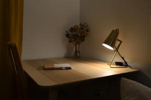 库尔布瓦Studio 88的一张桌子,上面有台灯,一本书和花瓶