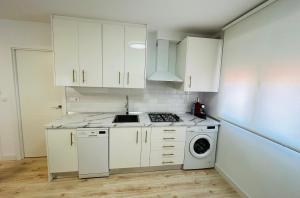 阿尔巴塞特Nórdico -Apartamentos Birdie-的厨房配有白色橱柜和洗衣机。