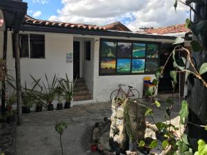 波哥大El Yarumo Hostel的前面有窗户和植物的房子