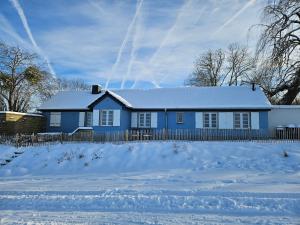 梅谢尼希Charmantes Eifel Ferienhaus an der Schavener Heide的前面有雪的蓝色房子