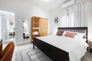 赖阿南纳Sweet and rural home in Ra’anana的白色卧室设有一张大床和镜子