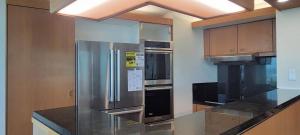 檀香山Moana Luxury Residence的厨房配有不锈钢冰箱和炉灶。