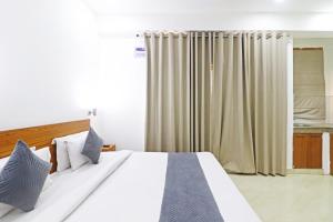 新德里Hotel Trendy residency的卧室配有白色大床和窗帘