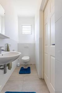 威廉斯塔德Cocobana Resort two-bedroom apartment ground floor的白色的浴室设有水槽和卫生间。