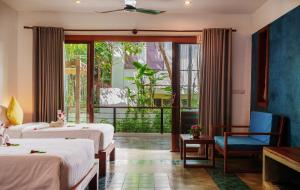 暹粒SAKABAN Suite的酒店客房设有两张床和一个阳台。
