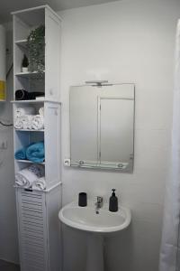 里韦拉布拉瓦Fifty´s House的浴室配有盥洗盆、镜子和毛巾
