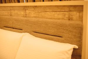 卡杜纳Hols Apartments的床头板,床上配有白色枕头