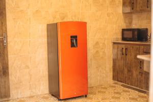 卡杜纳Hols Apartments的厨房里放着橙色和灰色的冰箱