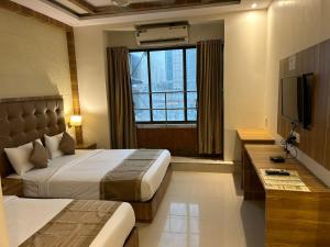 孟买Hotel BKC Mannat的酒店客房设有两张床和电视。