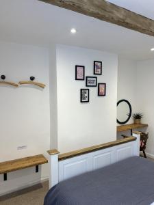 霍姆弗斯Nine Cooper Lane, Holmfirth的卧室配有墙壁上的白色墙壁和图片