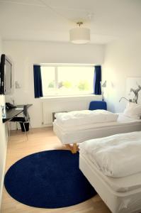 海宁海宁DGI酒店的一张桌子和蓝色地毯,配有两张床。