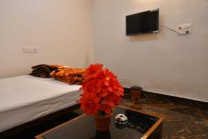 JasidihParadise Inn的一间卧室配有一张床和一个红色花瓶