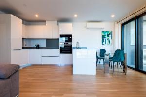 直布罗陀FORBES Suite1206-Hosted by Sweetstay的厨房以及带桌椅的起居室。