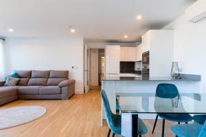 直布罗陀FORBES Suite1206-Hosted by Sweetstay的厨房以及带玻璃桌和椅子的客厅。