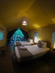 达瓦拉维阿瑟基拉河营地酒店 - 乌达瓦罗的一间帐篷内带两张床的卧室