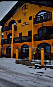 瓦特拉多尔内Casa Lupascu的黄色的建筑,旁边设有阳台