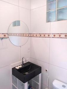 阿鲁雅Pousada Sol de Primavera的一间带黑色水槽和卫生间的浴室