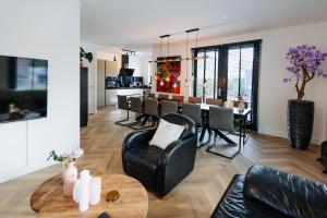 阿姆斯特丹Dutch Design Villa with 6 luxurious bedrooms的一间带桌子的客厅和一间餐厅