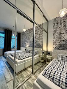 波普拉德Royal City Centre Apartment的卧室设有2张床,设有砖墙