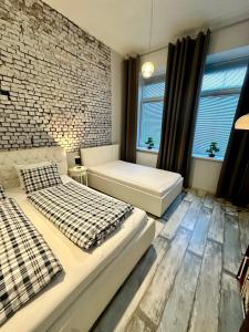 波普拉德Royal City Centre Apartment的一间卧室设有两张床和砖墙