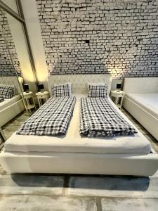 波普拉德Royal City Centre Apartment的砖墙客房的两张床
