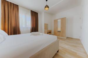 乌尔齐尼Family Resort的白色的卧室设有一张大床和一个窗户