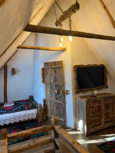 舒加塔格盐矿镇Casa Colț din Maramureș - Old Traditional House的一间带电视和一张帐篷床的卧室