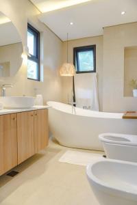 MahataoVilla Ferrer的带浴缸、盥洗盆和卫生间的浴室
