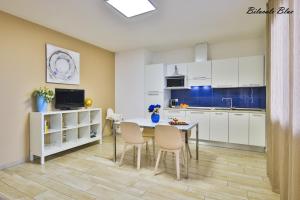 里米尼Casa Stefania Rimini的厨房配有白色橱柜和桌椅