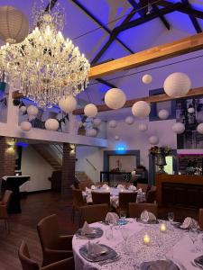 MerkelbeekB & B M 3的一间设有白色桌子和吊灯的用餐室