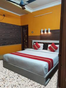 加尔各答Star VIP-Inn Kolkata Airport的一间卧室配有一张带红色枕头的大床