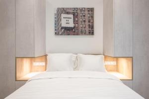 雅典Newly Renovated Escape/Psychiko的一张带白色床单和枕头的床