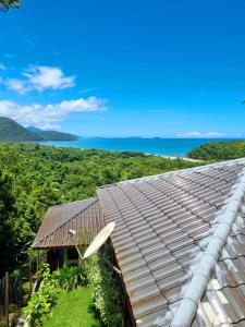 乌巴图巴Burung Flats Itamambuca - Hospedagem com vista para o mar的一座房子的屋顶,以海洋为背景
