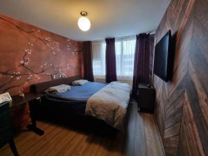阿姆斯特丹500-Mb Hi-Tech Silent Work-Home的一间卧室配有一张床,墙上挂着树壁画