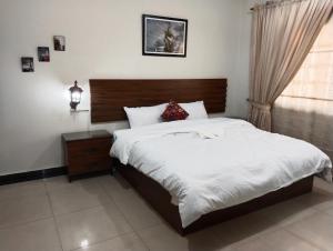 拉合尔King's Paradise的一间卧室配有一张大床和木制床头板