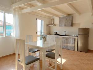 圣玛丽亚Branco Sea Holiday Apartments的厨房配有桌椅和冰箱。