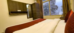 瑞诗凯诗Hotel Grace Ganga的一张位于带大窗户的房间内的床铺