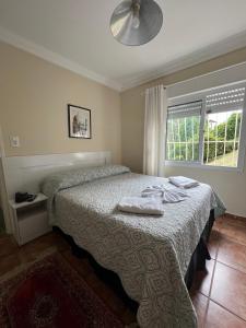 坎波斯杜若尔当拉谢拉望厦旅馆的一间卧室配有一张床,上面有两条毛巾