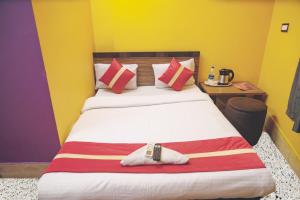加尔各答Star VIP-Inn Kolkata Airport的一间卧室设有一张大床,拥有红色和黄色的墙壁