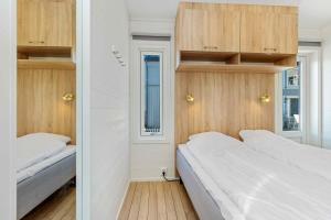 Nedre KileKosterbaden的小型客房配有2张床铺和木制橱柜。