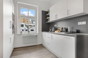 布拉迪斯拉发Air-conditioned Home Apartment Old Town的厨房配有白色橱柜和窗户。