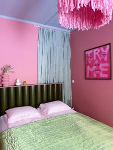 赫尔辛基Värikäs koti lähellä keskustaa的一间卧室设有绿色的床和粉红色的墙壁