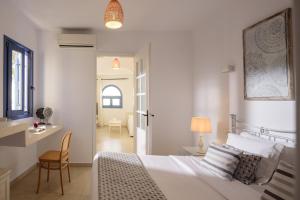 费拉Kamares Apartments的一间卧室配有一张床、一张桌子和一把椅子