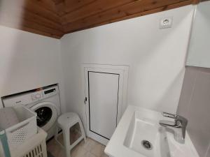 桑塔纳Maria's Cottage WiFi Park的白色的浴室设有洗衣机和水槽。