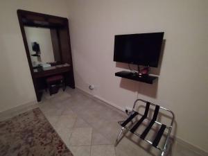 吉达فندق روتانة الحمراء的一间房间,墙上有椅子和电视