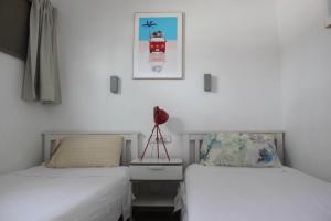 马斯帕洛马斯Relaxing Bungalow Playa del Inglés的白色墙壁客房的两张床