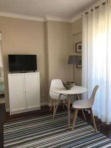 里斯本NEW Monsanto View Charming Apartment @ Campolide - 3B的客厅配有桌子和电视