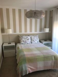 里斯本NEW Monsanto View Charming Apartment @ Campolide - 3B的一间卧室配有一张床、两个床头柜和两盏灯。