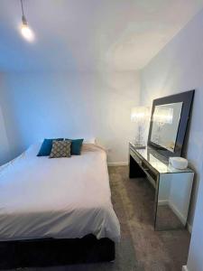 达格纳姆Modern 14th Floor 1or2-Bed Flat的一间卧室配有一张床和一张带镜子的书桌